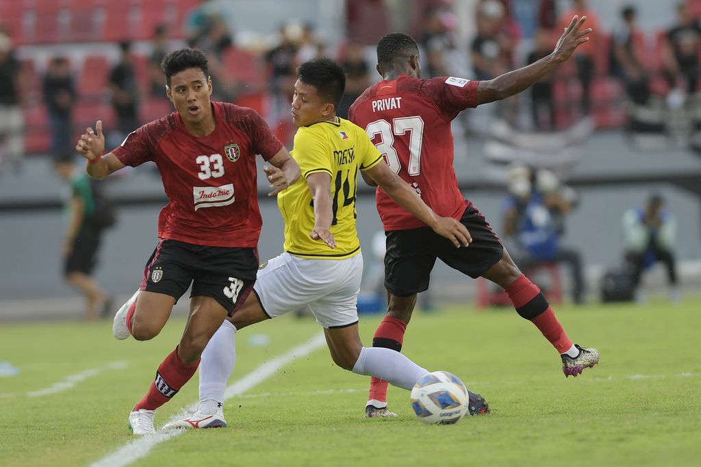 Bek kanan Bali United, Andhika Wijaya (kiri), melewati gelandang bertahan Kaya-Iloilo, Ryo Fujii (tengah), pada laga terakhir Grup G Piala AFC 2022 di Stadion I Wayan Dipta, Gianyar, Bali, Kamis (30/6/2022). 