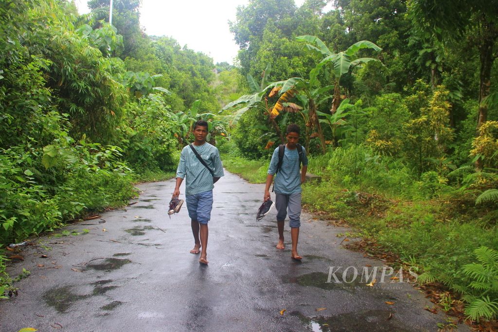 Siswa Sekolah Menengah Atas Negeri 1 Nusalaut di Pulau Nusalaut, Kabupaten Maluku Tengah, Maluku, berjalan kaki di bawah gerimis dari sekolah ke rumah seperti pada Kamis (6/4). Banyak sisiwa berjalan kaki dari rumah ke sekolah dengan jarak 3-7 km.