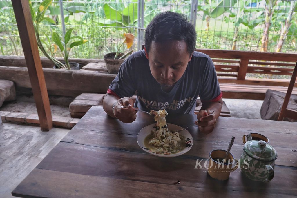 Pengunjung menyantap hidangan bakmi <i>godhog</i> (rebus) di warung Mas Timbul Tepi Sawah, Desa Banyuraden, Gamping, Sleman, DI Yogyakarta, Kamis (7/12/2023).