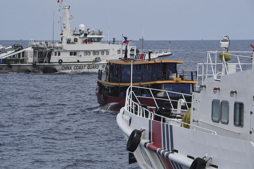 Arsip foto menunjukkan kapal penjaga pantai China (kiri dan kanan) memepet sebuah kapal sipil Filipina yang dicarter Angkatan Laut Filipina untuk mengangkut suplai di BRP Sierra Madre di wilayah yang disengketakan di perairan Laut China Selatan, 22 Agustus 2023. 