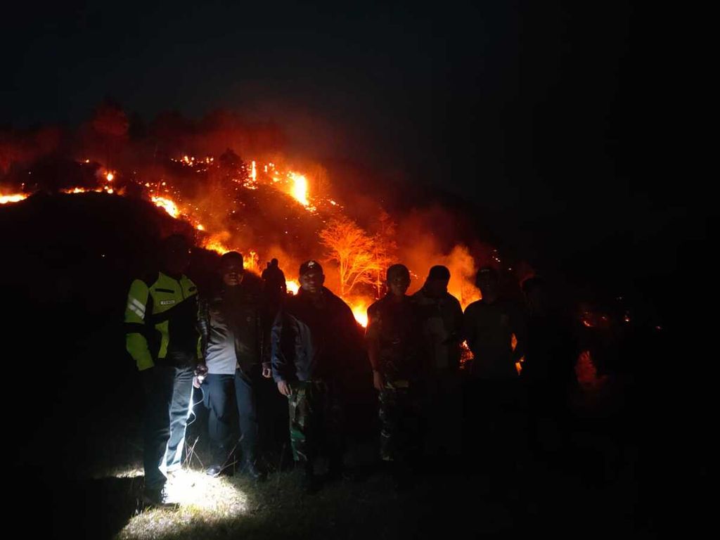 Sejumlah petugas berjaga di lereng Danau Toba yang terbakar di sekitar perkampungan Tulas Desa siboro, Kecamatan Sianjur Mulamula, Kabupaten Samosir, Sumatera Utara, Sabtu, (17/6/2023).