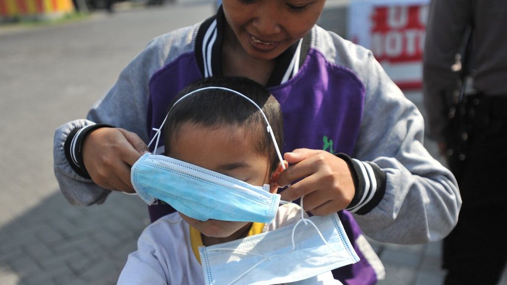 Warga memakaikan masker yang diberikan oleh polisi saat razia warga tidak bermasker di Kecamatan Waru, Sidoarjo, Jawa Timur, Rabu (5/8/2020). Razia tersebut untuk mengingatkan kembali kepada masyarakat bahwa Pandemi Covid-19 belum berakhir dan harus selalu mematuhi protokol kesehatan yang telah ditetapkan.
