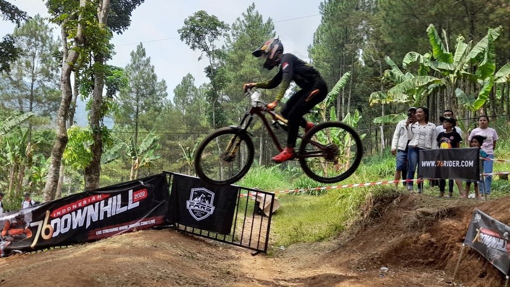 Seorang atlet downhill tengah melayang menaklukkan jalur Umbaran Bike Park di Desa Sidoluhur, Kecamatan Lawang, Kabupaten Malang, Jawa Timur, dalam final 76 Indonesian Downhill 2022, Minggu (18/9/2022).