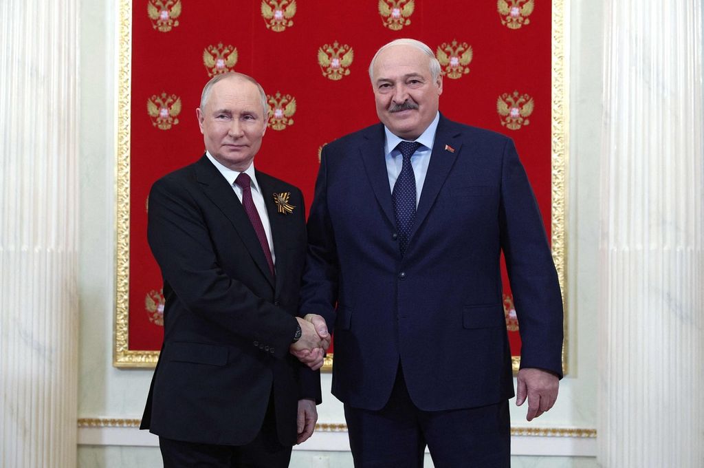 Presiden Rusia Vladimir Putin (kiri) berjabat tangan dengan Presiden Belarus Alexander Lukashenko di Istana Kremlin sebelum parade militer Hari Kemenangan di Moskwa, 9 Mei 2023. 