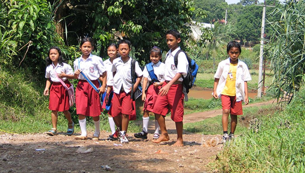 Siswa SD di Desa Tegal, Kecamatan Ciseeng, Kabupaten Bogor, Jawa Barat, berjalan pulang seusai sekolah.