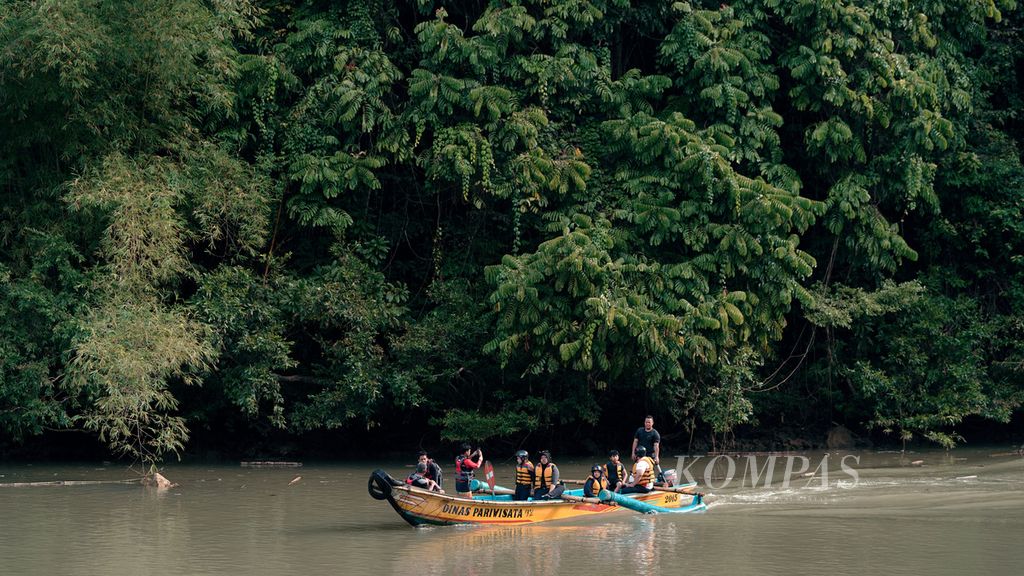 Wisatawan mengarungi Sungai Cijulang setelah mengikuti <i>body rafting</i> melintasi Green Canyon di Kabupaten Pangandaran, Jawa Barat, Senin (8/8/2022). Penamaan Green Canyon tersebut karena saat kemarau warna air Sungai Cijulang yang mengalir di antara tebing karang terlihat berwarna hijau bening. Wisatawan bisa memacu adrenalin dengan mengikuti <i>body rafting,</i> yakni aktivitas perorangan mengarungi sungai dengan rompi pelampung dan helm pengaman. Aktivitas Green Canyon (Cukang Taneuh) dibatasi maksimal 500 tiket dalam sehari.