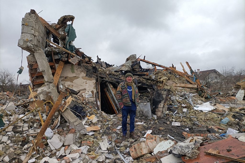 Seorang pria Ukraina berdiri di puing-puing rumah di Zhytomyr, Rabu (2/3/2022), setelah pengeboman Rusia sehari sebelumnya. Menurut penduduk setempat, penembakan itu menewaskan sedikitnya 3 orang dan melukai hampir 20 warga. 