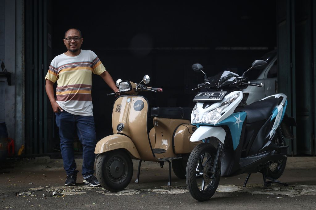 CEO Spora EV Triharsa Adicahya berfoto bersama dua sepeda motor berbasis bahan bakar minyak (BBM) yang telah dikonversi menjadi sepeda motor listrik di bengkel Spora EV, Serpong Utara, Tangerang Selatan, Kamis (23/3/2023). 