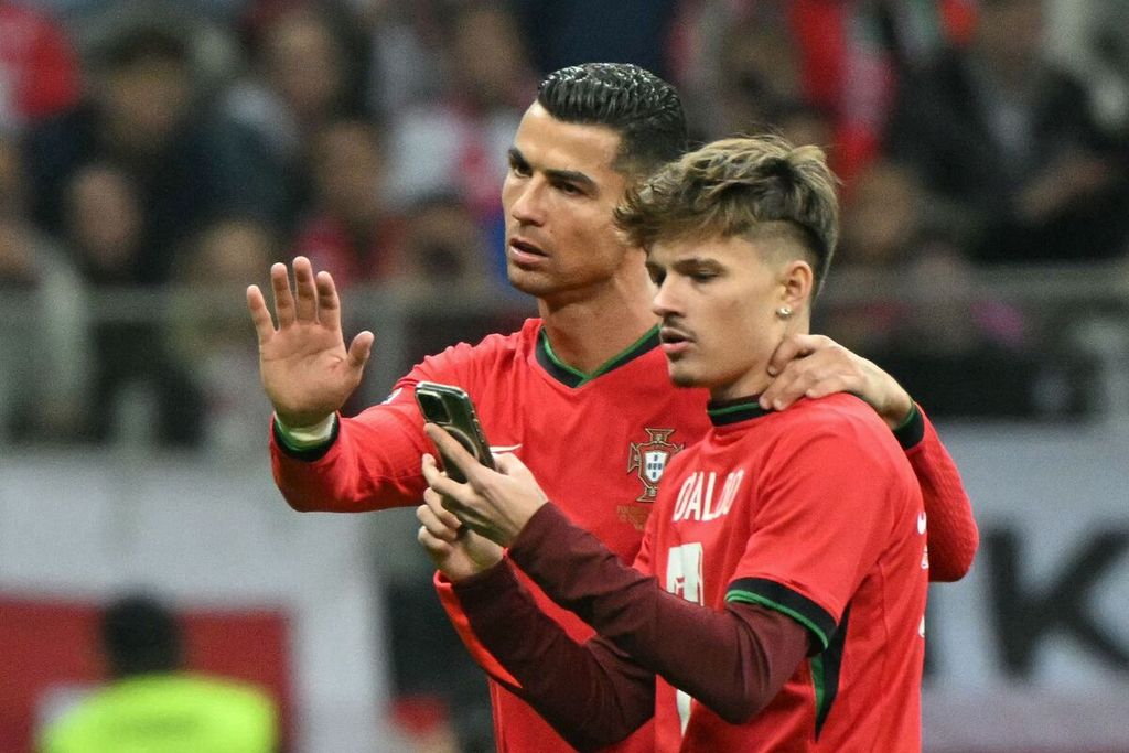 Penyerang Portugal, Cristiano Ronaldo (kiri), berswafoto dengan penggemarnya yang menerobos masuk lapangan seusai menghadapi Polandia pada laga Liga Nasional Eropa di Stadion Warsawa, Polandia, Minggu (13/10/2024) dini hari WIB. Portugal menang 3-1, Ronaldo menyumbang satu gol.