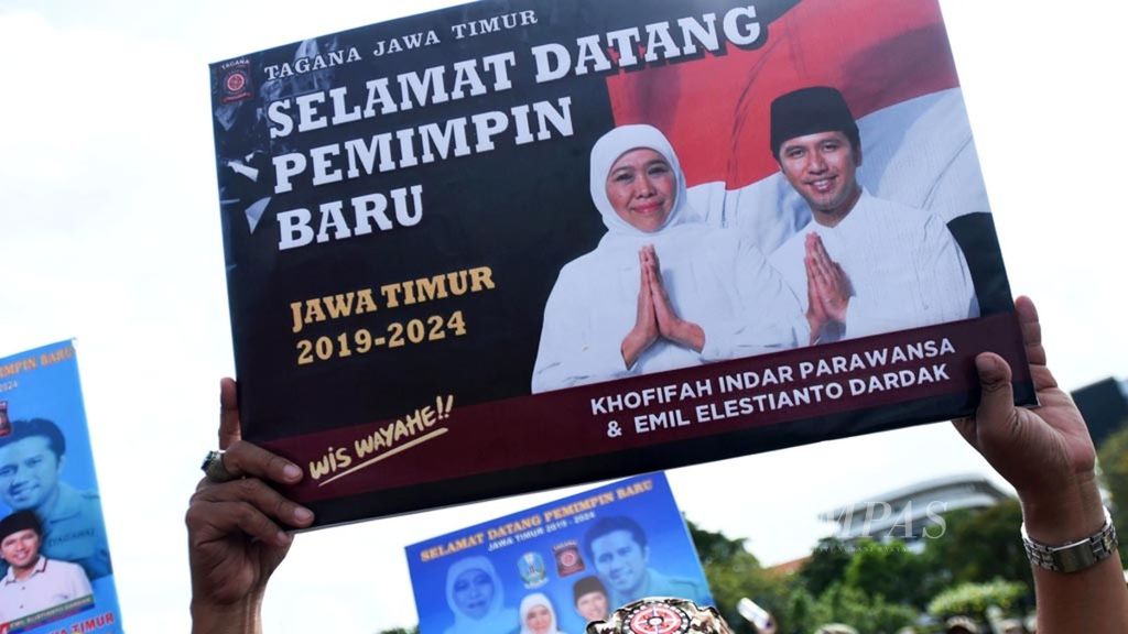 Citizens held up posters while waiting for the newly inaugurated Governor of East Java, Khofifah Indar Parawansa, and Vice Governor of East Java, Emil Elistianto Dardak, who were visited by President Joko Widodo during a procession from Masjid Al-Akbar to Gedung Grahadi, Surabaya, on Thursday (14/2/2019). This pair was again supported by the Democratic Party in the East Java regional election in November 2024.