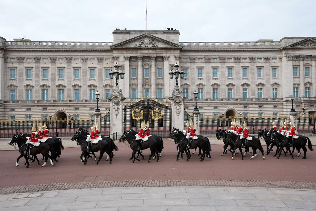 Pasukan pengawal kerajaan berbaris melewati Istana Buckingham saat pemakaman Ratu Elizabeth II di London, Inggris, Senin (19/9/2022). 