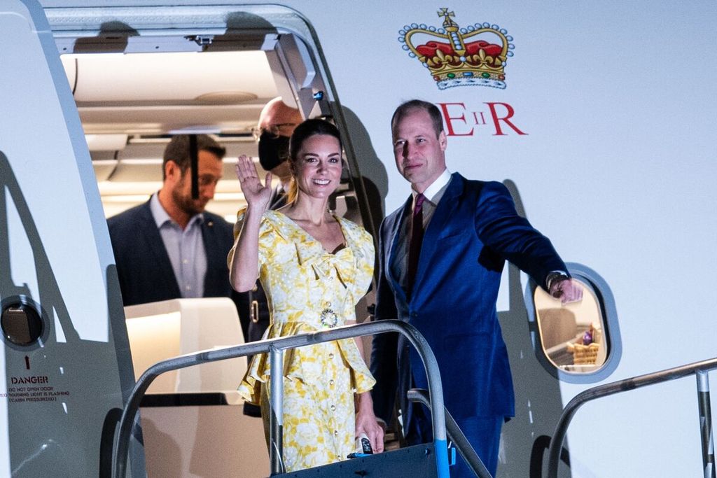 Pangeran William dari Inggris (kanan) dan Catherine, Duchess of Cambridge (tengah), melambaikan tangan saat akan memasuki pesawat di Bandar Udara Internasional Lynden Pindling, Nassau, Bahama, Sabtu (26/3/2022). 
