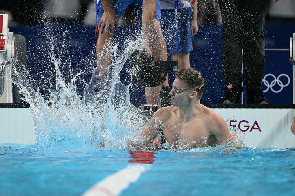 Perenang Perancis, Leon Marchand, melakukan selebrasi usai meraih emas nomor renang 200 meter gaya dada Olimpiade Paris di Paris La Defense Arena, Nanterre, Rabu (31/7/2024).