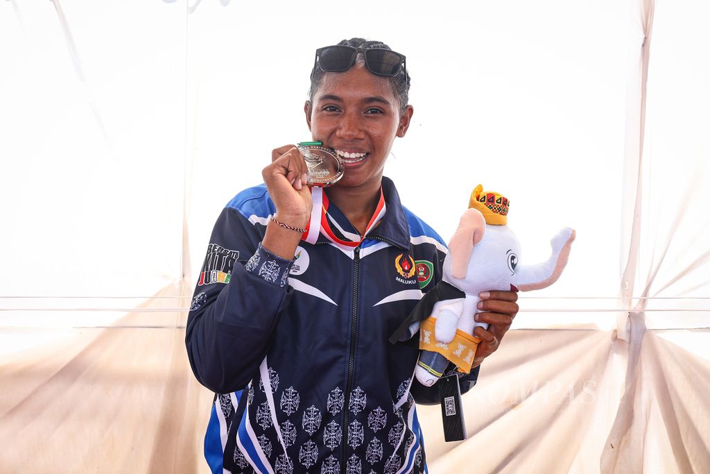 Atlet dayung Maluku, Issa Behuku, berpose setelah menerima medali cabang dayung rowing nomor single sculls dan quadraple sculls dalam PON Aceh-Sumut 2024 di Waduk Keuliling, Aceh Besar, Aceh, Kamis (12/9/2024). KOMPAS/ADRYAN YOGA PARAMADWYA (YGA) 12-09-2024