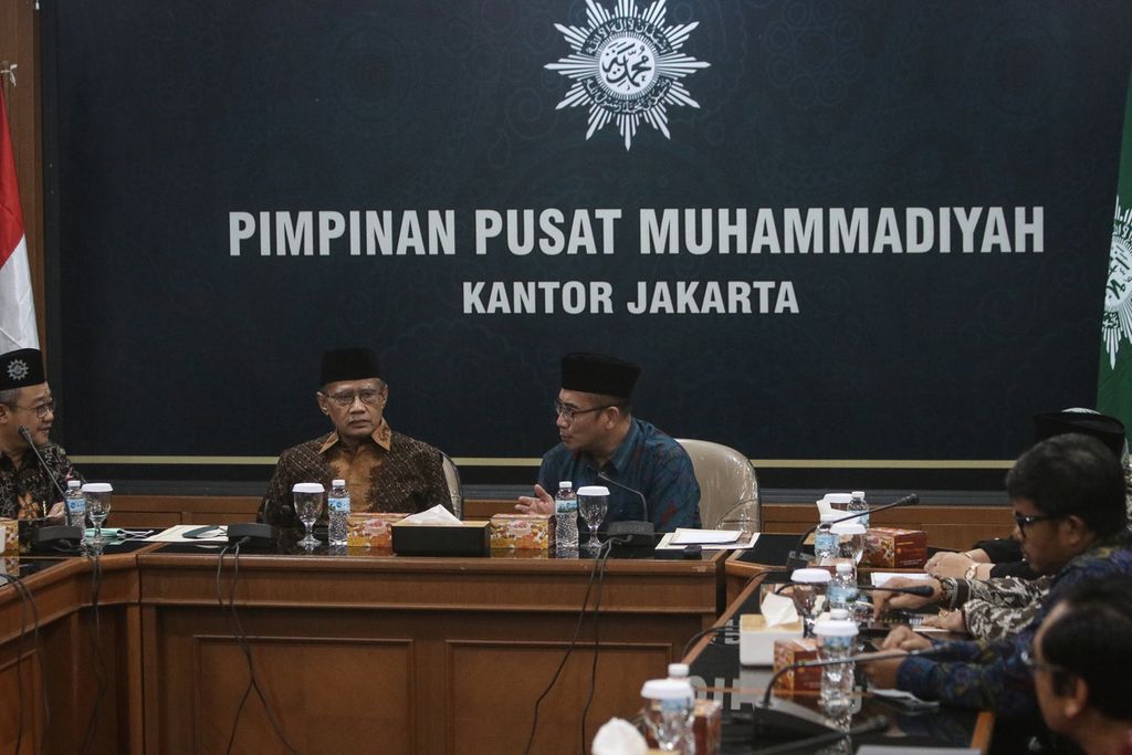 Ketua PP Muhammadiyah Haedar Nashir (tengah) berbincang dengan Ketua KPU RI Hasyim Asy'ari (kanan) dalam pertemuan di Gedung Pusat Dakwah Muhammadiyah, Jakarta, Selasa (3/1/2023). 