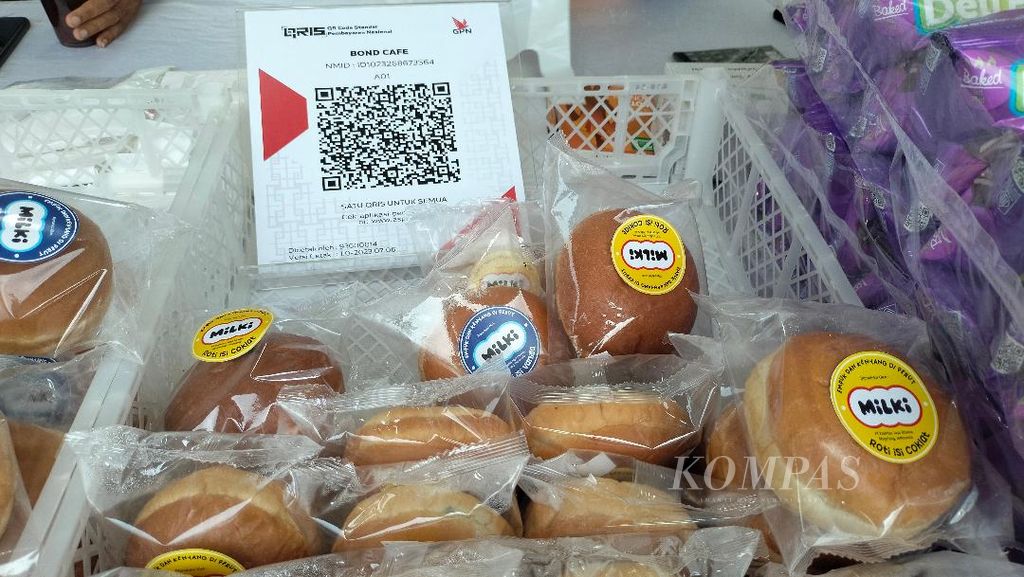 Papan <i>barcode </i>QRIS dipajang oleh pelaku usaha roti di samping produk dagangannya di Magelang, Jateng, Jumat (7/7/2023).