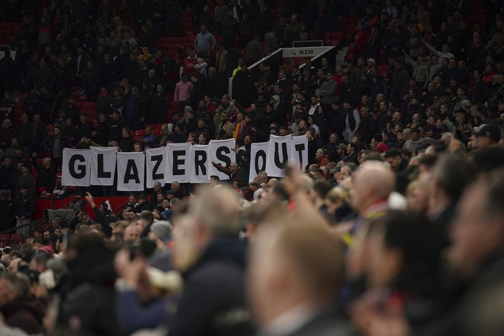 Suporter Manchester memperlihatkan poster bertuliskan, "Glazers Out" saat tim kesayangan mereka menghadapi Chelsea pada laga Liga Inggris di Stadion Old Trafford, Manchester, Jumat (29/4/2022) dini hari WIB. Laga itu berakhir imbang, 1-1.