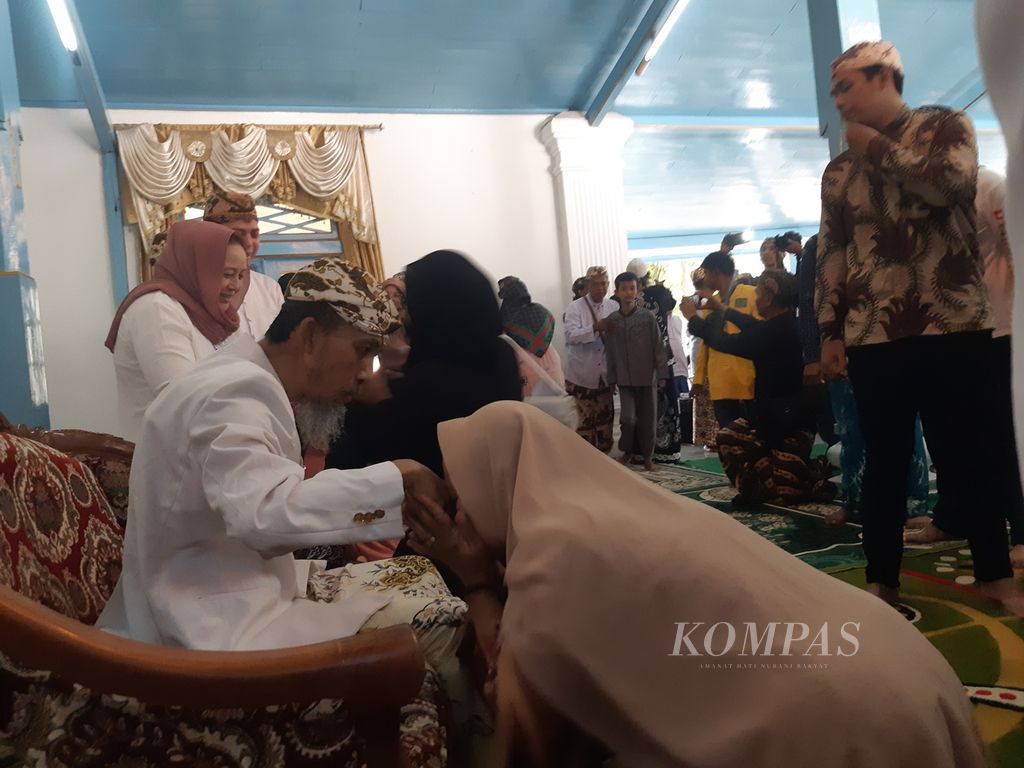 Warga mengantre untuk bersalaman dengan Sultan Kanoman XII Raja Muhammad Emirudin (duduk di kursi) saat <i>pisowanan ageng</i> di Pendopo Jinem, Keraton Kanoman, Kota Cirebon, Jawa Barat, Senin (15/4/2024). 
