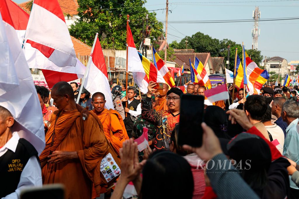 Warga menyambut 33 biksu yang berjalan kaki saat mereka akan singgah di Wihara Adi Dharma, Kota Semarang, Jawa Tengah, Minggu (28/5/2023). 