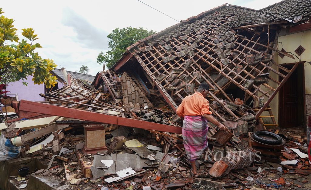 Seorang warga Kampung Rawacina, Nagrak, Kecamatan Cianjur, Kabupaten Cianjur, Jawa Barat, mengumpulkan benda-benda yang bisa diselamatkan, Rabu (23/11/2022). 
