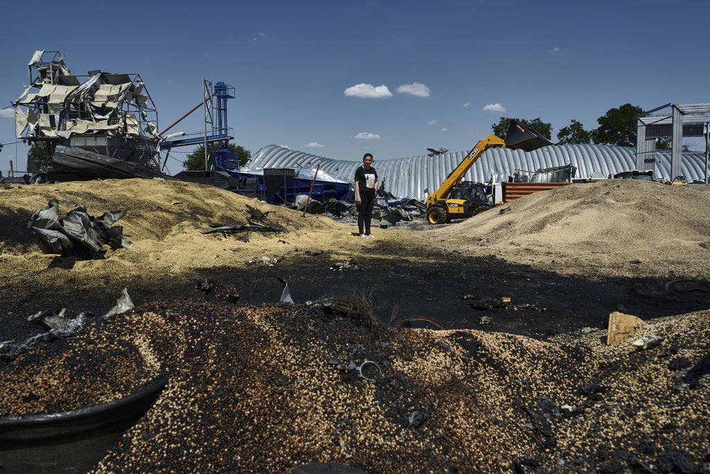 Olha berdiri di atas tumpukan gandum rusak akibat serangan mliter Rusia di Odessa, Ukraina, Jumat (21/7/2023). Tiga hari berselang setelah serangan itu, militer Rusia menyerang fasilitas penyimpanan dan ekspor biji-bijian Ukraina di Sungai Danube, 
