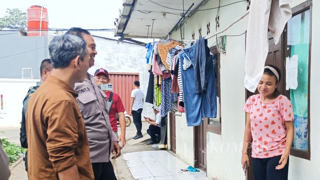 Ketua RW 002 Marat (baju coklat) bersama polisi berkomunikasi dengan penghuni tempat indekos di RT 007 RW 002, Kampung Poncol, Kelurahan Babakan, Setu, Kota Tangerang Selatan, Senin (6/5/2024), sore.