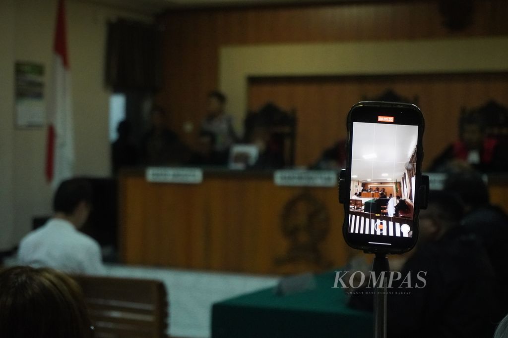 Warga melakukan siaran langsung sidang vonis terhadap Daniel Frits Maurits Tangkilisan, aktivis lingkungan yang tengah terjerat kasus pelanggaran Undang-Undang ITE, di Pengadilan Negeri Jepara, Jawa Tengah, Kamis (4/4/2024). 
