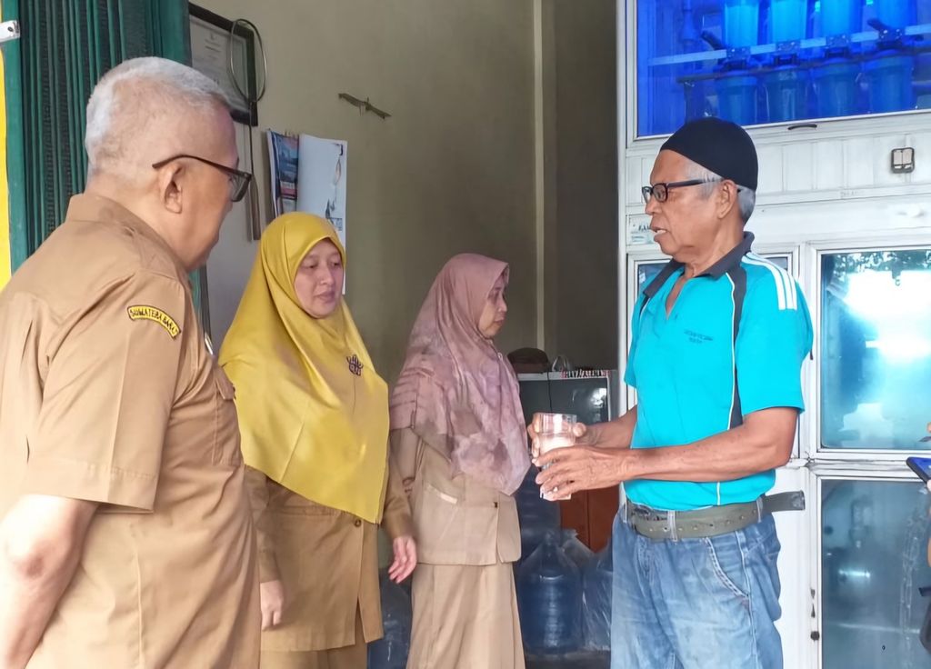 Kepala Dinas Perizinan dan Pelayanan Terpadu Satu Pintu Kabupaten Pesisir Selatan Nuzirwan (kiri) mendatangi depot air galon isi ulang di Kecamatan Surantiah, Pesisir Selatan, Sumatera Barat, Selasa (7/5/2024).