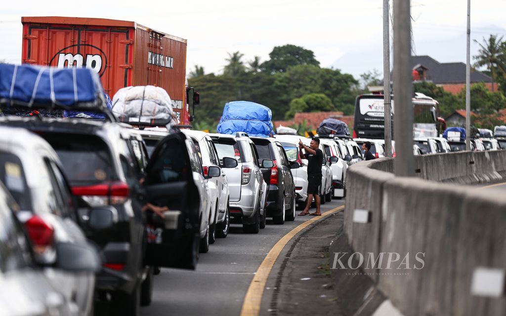 Pemudik keluar dari kendaraannya saat terjebak kemacetan di Kilometer 96 jelang pintu keluar Gerbang Tol Merak di Cilegon, Banten, Kamis (28/4/2022).