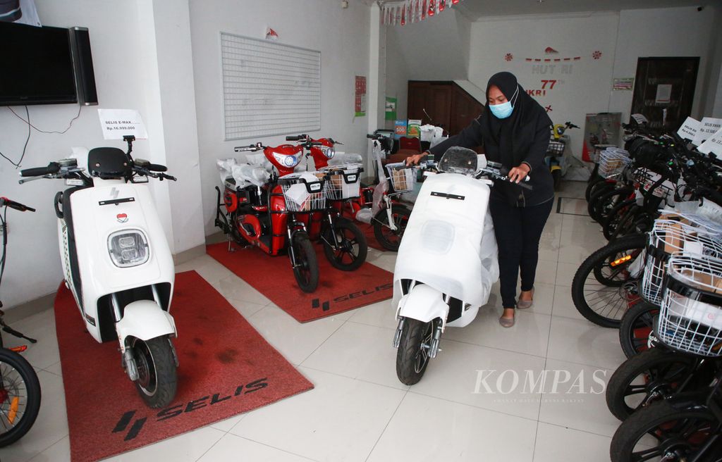 Pramuniaga mempersiapkan sepeda motor listrik yang telah laku dijual di dealer resminya di Kota Tangerang, Banten, Senin (12/12/2022). Pemerintah tengah menggodok sejumlah paket insentif untuk memberikan subsidi pembelian kendaraan listrik kepada masyarakat.