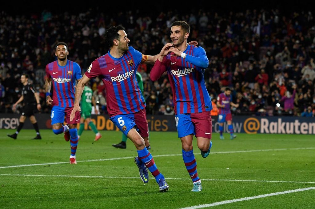 Pemain Barcelona, Sergio Busquets (tengah), ikut merayakan gol yang diciptakan Ferran Torres (kanan) ke gawang Osasuna pada laga Liga Spanyol di Stadion Camp Nou, Barcelona, Senin (14/3/2022). Pada laga itu, Barcelona menang dengan skor 4-0. 
