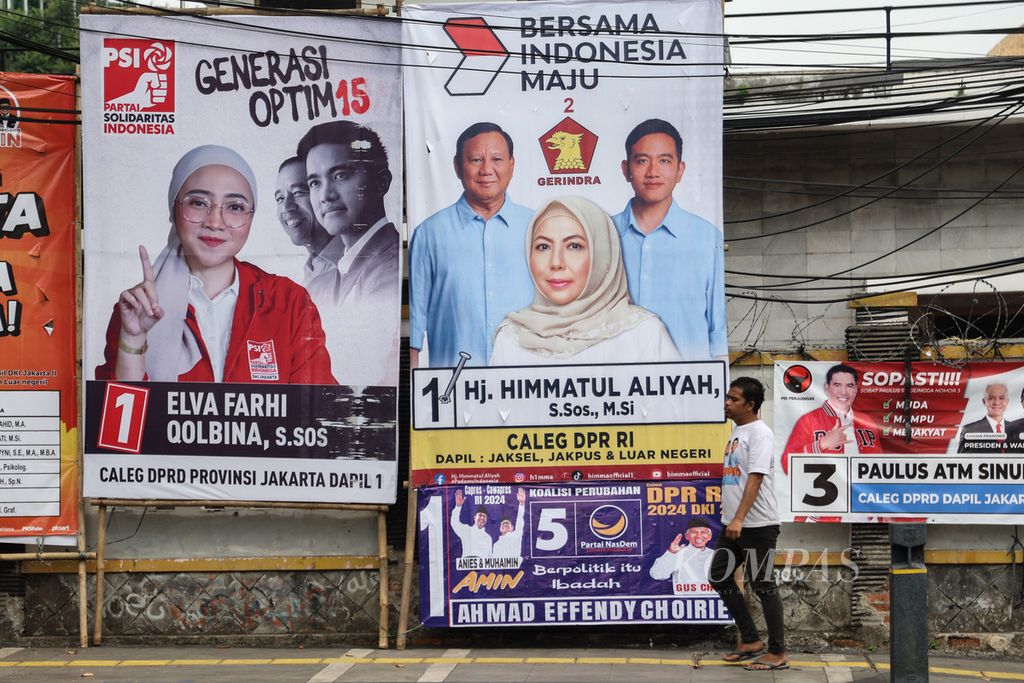 Warga berjalan di depan alat peraga kampanye caleg Pemilu 2024 di Jalan Matraman Raya, Jakarta, Rabu (6/12/2023). 