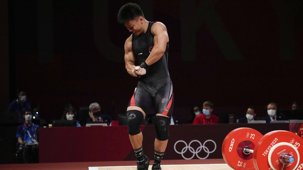 Lifter Indonesia, Rahmat Erwin Abdullah, menunjukkan otot tubuhnya seusai mengangkat beban dalam lomba angkat besi kelas 73kg putra Olimpiade Tokyo 2020 di Tokyo International Forum, Tokyo, Jepang, Rabu (28/7/2021). 