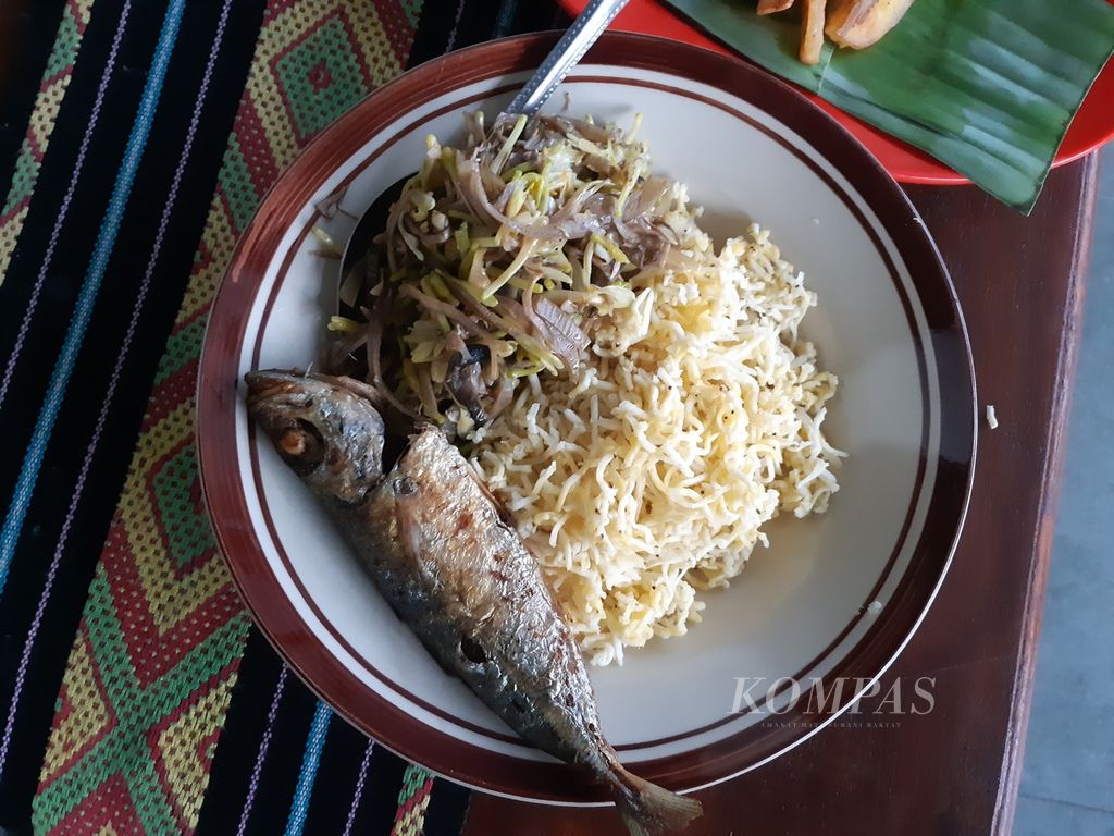 Menu makan Tuti Lawalu (43) berupa parutan buah pisang rebus sebagai pengganti nasi, sayur, dan ikan untuk makan malam pada Selasa (21/3/2023). Sudah lebih dari satu tahun warga Kota Kupang, Nusa Tenggara Timur, itu tidak lagi mengonsumsi nasi. 