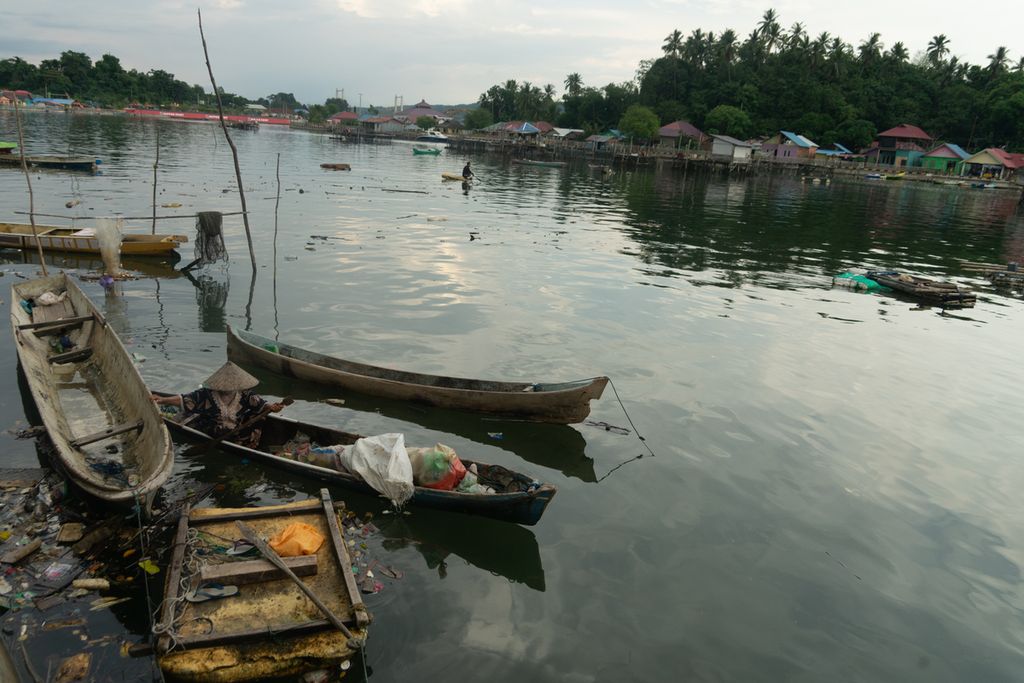 Hanafiah (60) memungut sampah plastik dari pesisir Teluk Kendari, Sulawesi Tenggara, Minggu (2/1/2022). Janda berusia lanjut ini bertahan hidup dengan memulung sampah plastik setiap hari. Ia dan sejumlah perempuan pemulung lain tidak mendapat bantuan dari pemerintah sama sekali meski berulang kali didata.