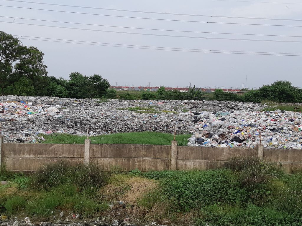 Kondisi tumpukan sampah yang diapit proyek Tol Cibitung Cilincing dan Kali Cikarang Bekasi Laut, di Desa Sumberjaya, Tambun Selatan, Kabupaten Bekasi,  Selasa (25/1/2022) sore.