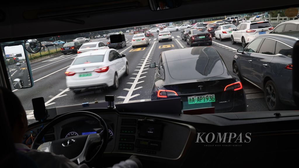 Mobil listrik dengan nomor polisi berwarna hijau muda ditemui di sepanjang perjalanan mengelilingi kota Hangzhou, China, Kamis (28/9/2023). China dan Tesla menjadi pemicu utama kehadiran mobil listrik. 