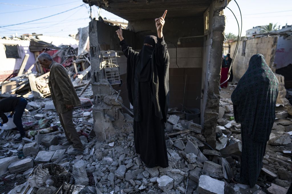 Warga Palestina menyaksikan kehancuran setelah serangan Israel di Rafah, Jalur Gaza selatan, 18 Januari 2024. 