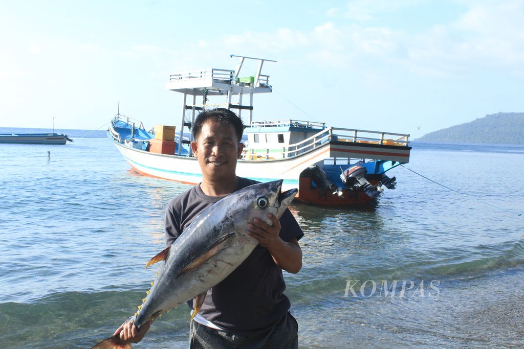 Seorang warga menunjukkan ikan tuna hasil tangkapan nelayan di Desa Kawa, Kecamatan Seram Barat, Kabupaten Seram Bagian Barat, Maluku, Senin (4/9/2023). Ikan tuna merupakan salah satu potensi perikanan di daerah itu. 