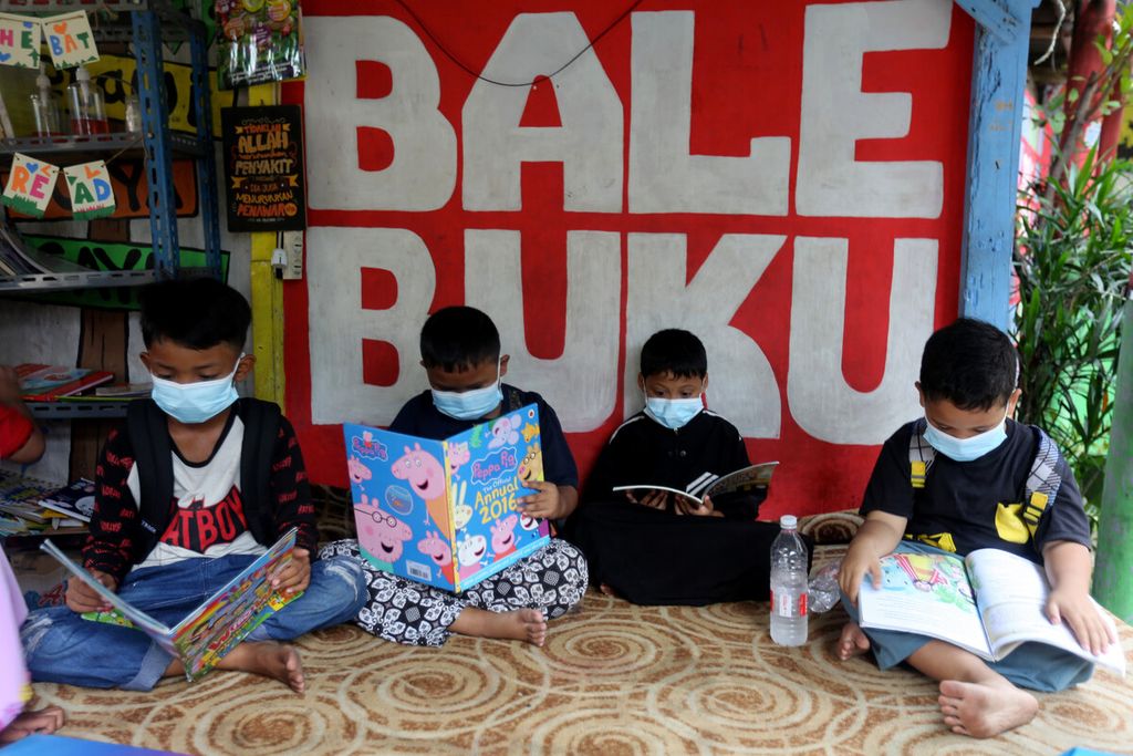 Anak-anak membaca buku di Bale Buku di perkampungan Gang Dendrit, RT 004 RW 008, Kecamatan Cakung, Jakarta Timur, Senin (29/11/2021). Bale ini berawal dari pos ronda yang disulap menjadi perpustakaan untuk anak-anak. Sebagian buku disumbang dari Sudin Perpustakaan Jakarta Timur, sebagian lagi dari donasi warga sekitar, komunitas, dan perorangan pencinta buku.