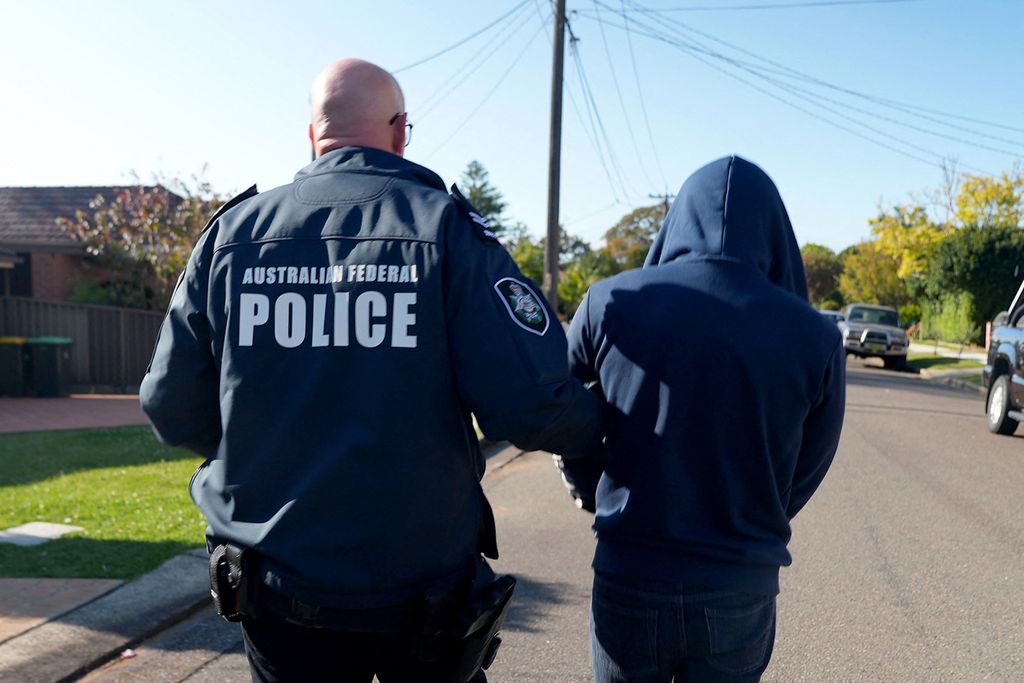 Foto yang dikeluarkan Kepolisian Federal Australia (AFP) memperlihatkan salah seorang petugas membawa tersangka Jay Je Yoon Jung (32), pengembang dan admin aplikasi percakapan Ghost dari rumahnya di Sydney barat daya, Australia, Selasa (17/9/2024). Aplikasi yang dikembangkan Jung diduga menjadi aplikasi yang banyak digunakan kelompok kriminal terorganisasi di Australia dan sejumlah negara.