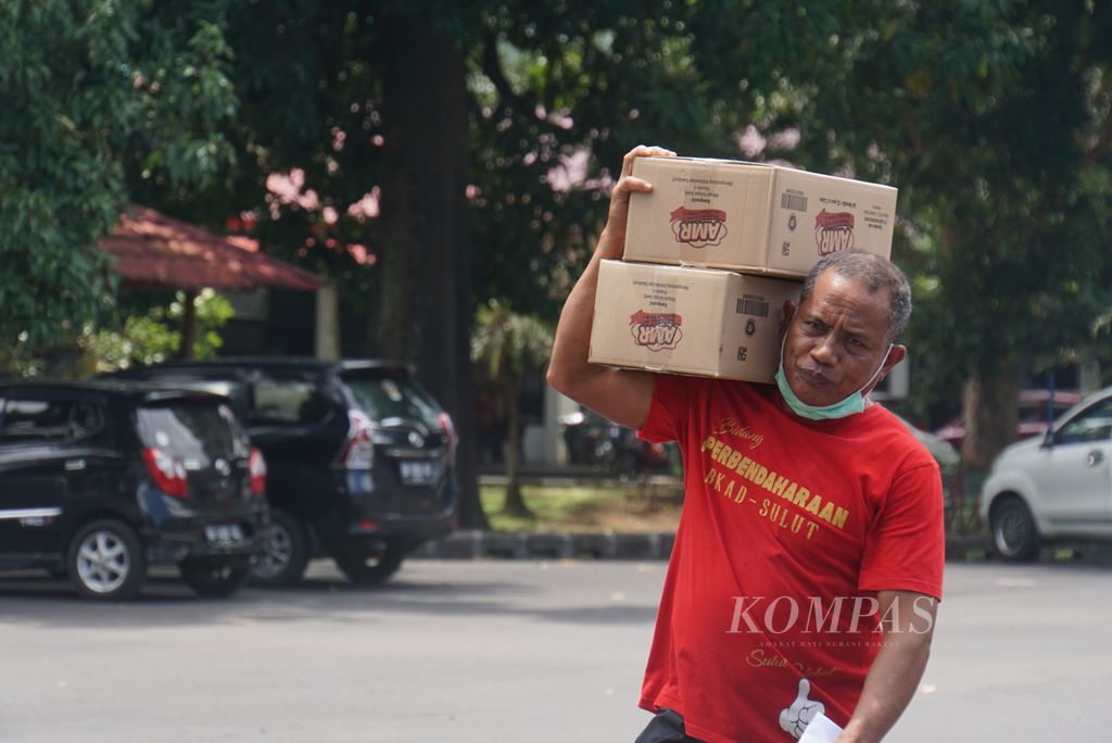 Seorang pegawai Pemerintah Provinsi Sulawesi Utara memanggul dua kardus minyak goreng kemasan sederhana yang ia beli seharga Rp 13.500 per liter di halaman belakang Kantor Gubernur Sulut di Manado, Jumat (11/3/2022). Dinas Perindustrian dan Perdagangan dan Badan Urusan Logistik (Bulog) menyediakan stok sekitar 2.500 liter.