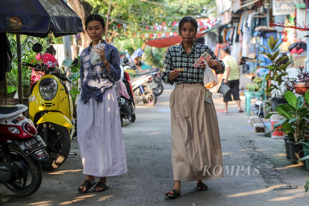 Dua remaja berjalan di Kampung Kerapu di Kecamatan Pademangan, Jakarta Utara, Kamis (3/8/2023). 