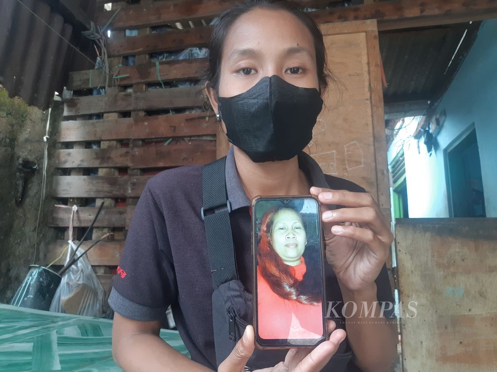 Sri Rejeki (27) menunjukkan potret Sutinih (47), ibunya, di Desa Dadap, Kecamatan Juntinyuat, Kabupaten Indramayu, Jawa Barat, Sabtu (22/1/2022). Selama 13 tahun, Sri tidak berjumpa dengan ibunya yang menjadi pekerja migran di Irak. Keluarga berharap Sutinih segera pulang.