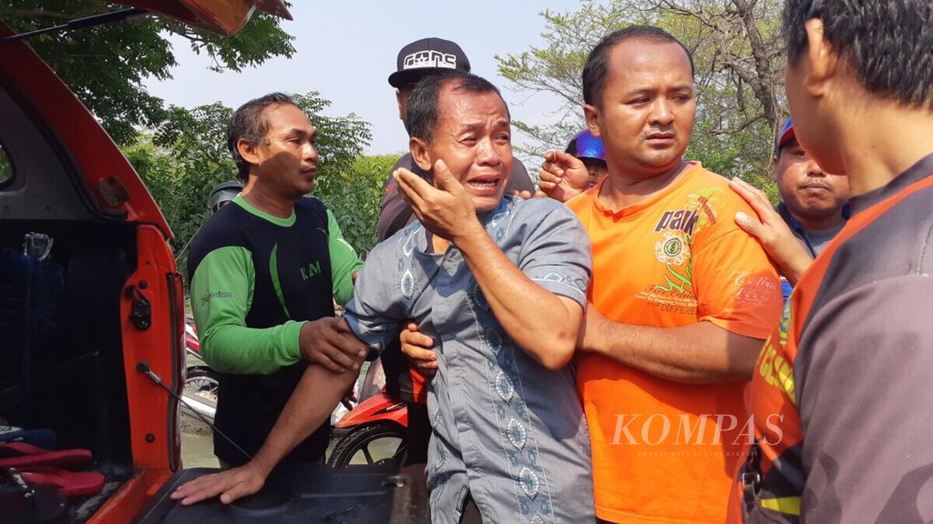 Ayah Bagus Akbar menangis ketika anaknya ditemukan tewas terseret arus luapan Kali Lamong di Tambakberas, Kecamatan Cerme, Kabupaten Gresik, Jawa Timur Minggu (5/5/2019)