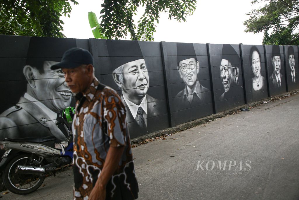 A man walks past a mural of the faces of former and Indonesian Presidents on Jalan H Ba'an, Poris Plawad Indah, Tangerang City, Banten, Sunday (16/5/2021).