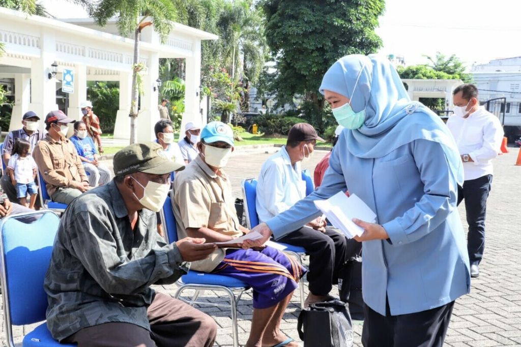 Gubernur Jawa Timur Khofifah Indar Parawansa membagikan tunjangan hari raya kepada masyarakat berpenghasilan rendah terdampak Covid-19, Senin (10/5/2021), di Surabaya.
