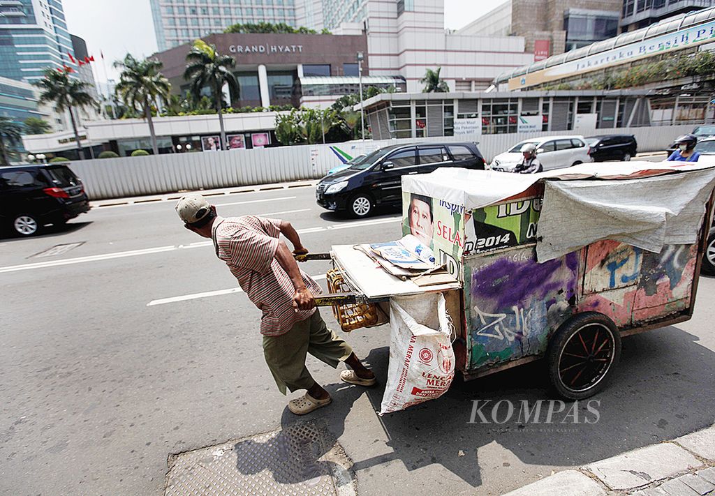 Warga membawa serta keluarganya dalam gerobak melintasi Jalan Thamrin, Jakarta, Kamis (20/2/2014). 