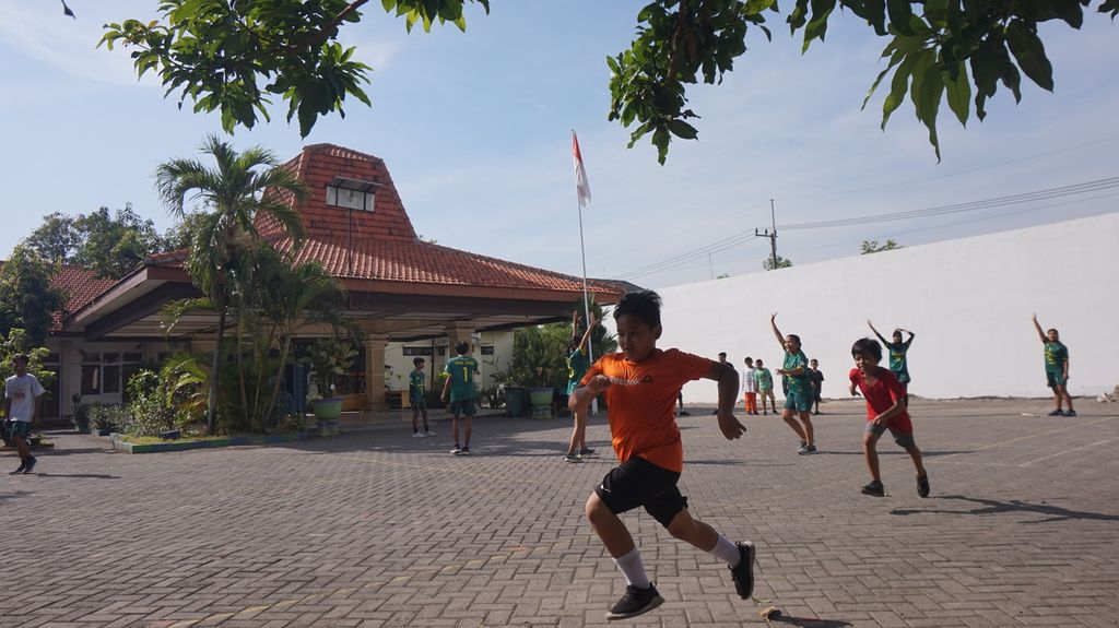 Suasana permainan kasti oleh anak dan remaja anggota Club/Klub Olahraga Tradisional Jambangan (Cortraj/Kortraj) di halaman Kelurahan Jambangan, Surabaya, Jawa Timur, Minggu (25/9/2022). Setiap Sabtu dan atau Minggu pagi atau sore, warga Jambangan berlatih dan bermain olahraga rekreasi dan permainan tradisional untuk pelestarian dan pengembangan. 