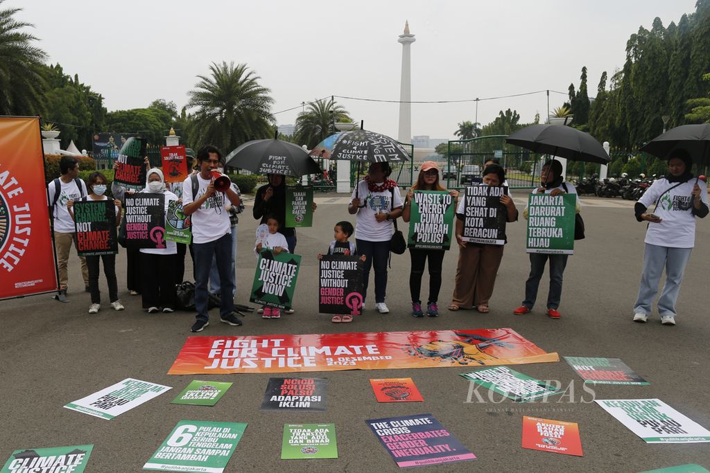 Aktivis Wahana Lingkungan Hidup Indonesia (Walhi) menggelar aksi damai di depan Istana Merdeka, Jakarta, Sabtu (9/12/2023). Walhi mengkritisi pertemuan UNFCCC COP 28 yang saat ini sedang berlangsung di Dubai.  